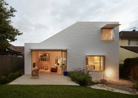 澳大利亚悉尼郊区大院子-东北角的顶轮廓线的斜坡，可以让自然光进入庭院屋，小厨房保持最小的全白，采用白色混合砖墙机构