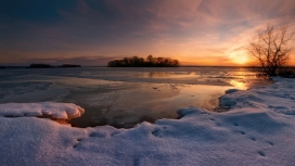日落下的冬季结冻湖