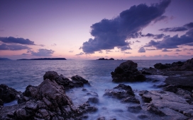 紫色天空下的海洋俏丽岩石
