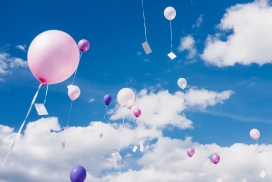 冲向蓝天中的粉红与紫色气球