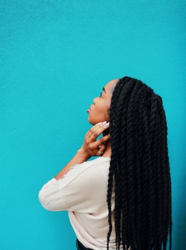 蓝色墙前的长黑发非洲女郎