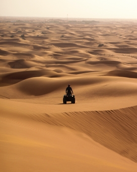 行驶在沙漠中的四角越野摩托车