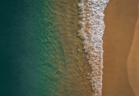 高空俯拍的蓝色海滩海浪图
