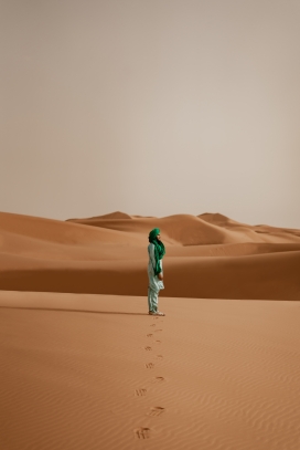 行走在沙漠上留下脚印的中东旅行者