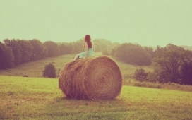 夏季的一天-坐在圆形草垛上的少女