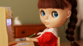 在课桌前写字的漂亮女娃娃