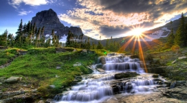 光芒四射日出下的小溪瀑布自然风景