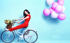 高清晰骑带粉红气球自行车的倪妮