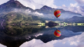 飞跃在湖泊上的热气球壁纸