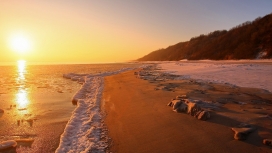 日落下的海洋沙滩山泡沫