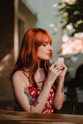 红发纹身品咖啡的女子