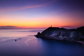 紫色海岸线下的远方灯塔
