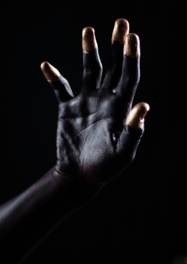 手指前端涂满金箔的非洲黑人手