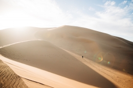 阳光下攀登沙漠的旅行者