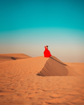 坐着沙漠上的红衣女郎