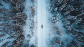 高空航拍行驶在冬季森林中的汽车